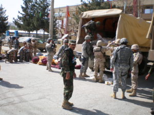 Scott Delius in military gear assisting others